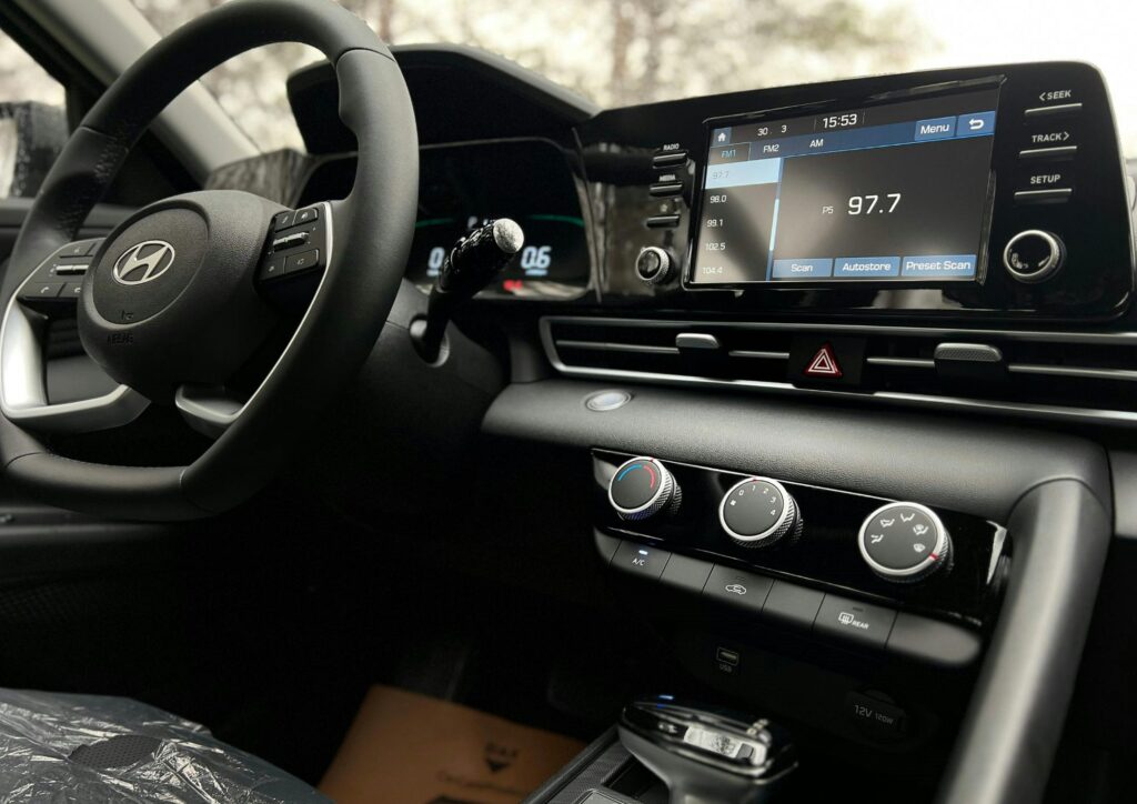 Interior view of a modern car dashboard featuring a touchscreen infotainment system and steering wheel.